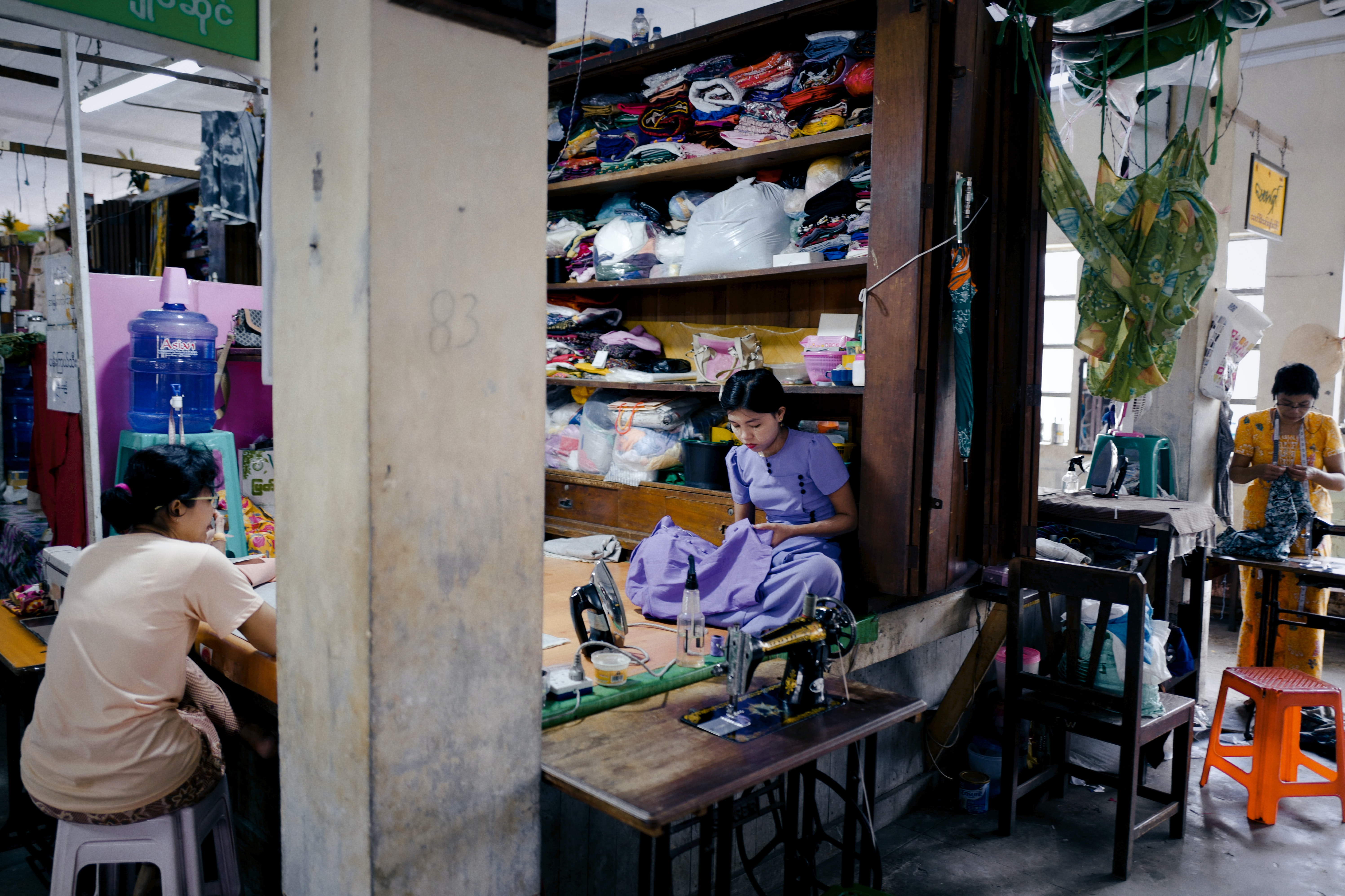 Woman sitting sewing garments